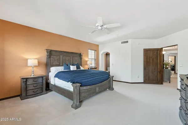 a bed sitting in a spacious bedroom next to a window