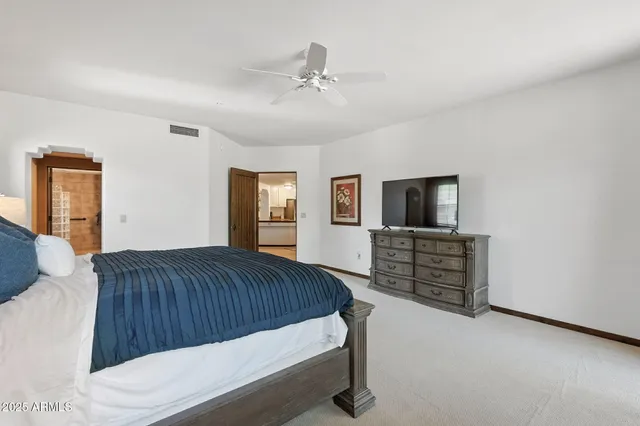 a bed sitting in a spacious bedroom next to a window