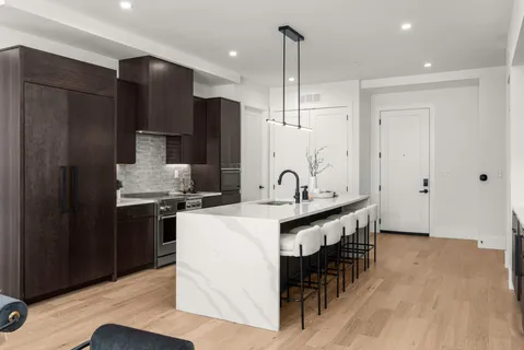 a kitchen with stainless steel appliances granite countertop a sink a stove and a refrigerator