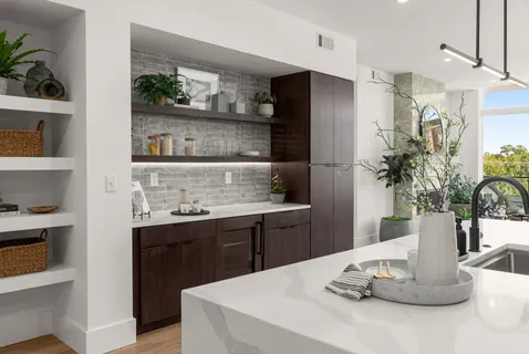 a kitchen with a table and potted plant