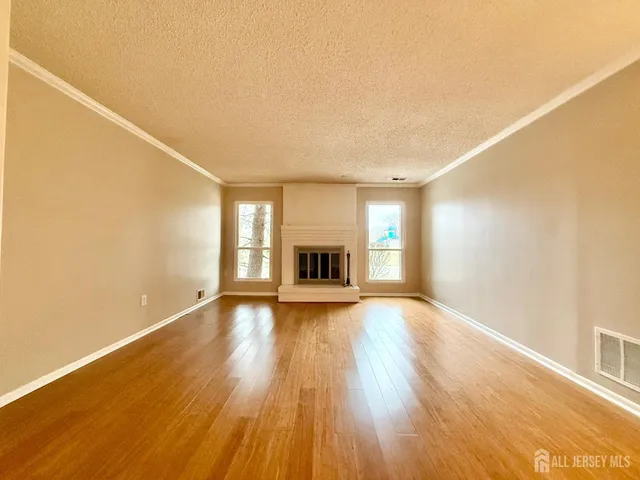 a view of an empty room with a fireplace and a window