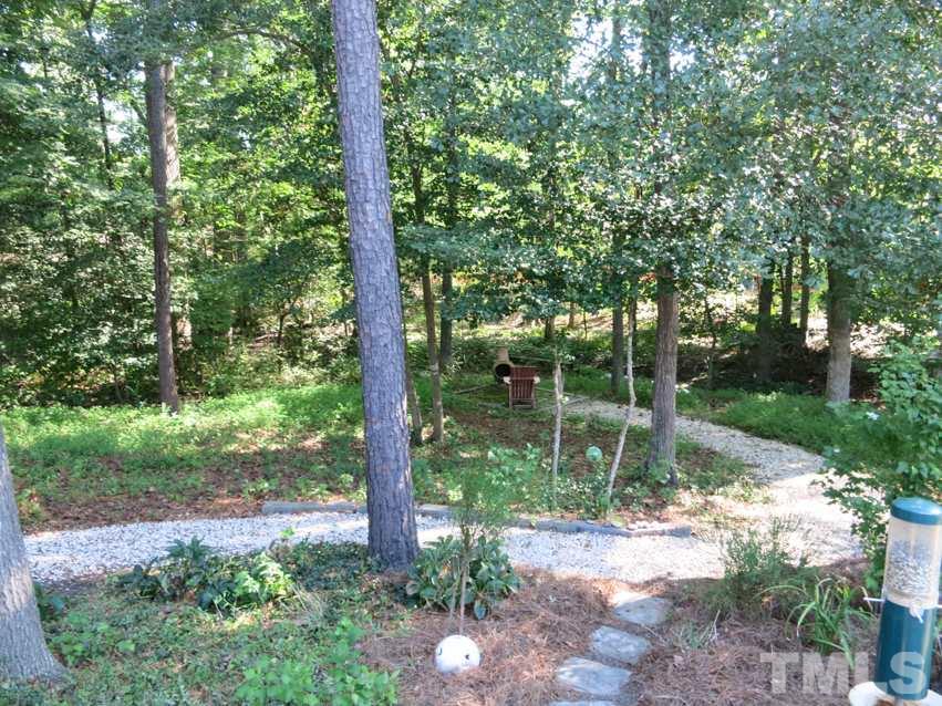 4629 Landover Crest Drive Raleigh, NC 27616 - Photo 22 of 25 View of the nicely landscaped backyard shaded by tall trees.