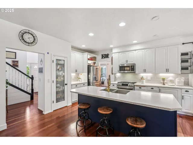 a kitchen with stainless steel appliances granite countertop a sink stove and refrigerator