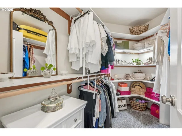 a utility room with stainless steel appliances lots of white furniture