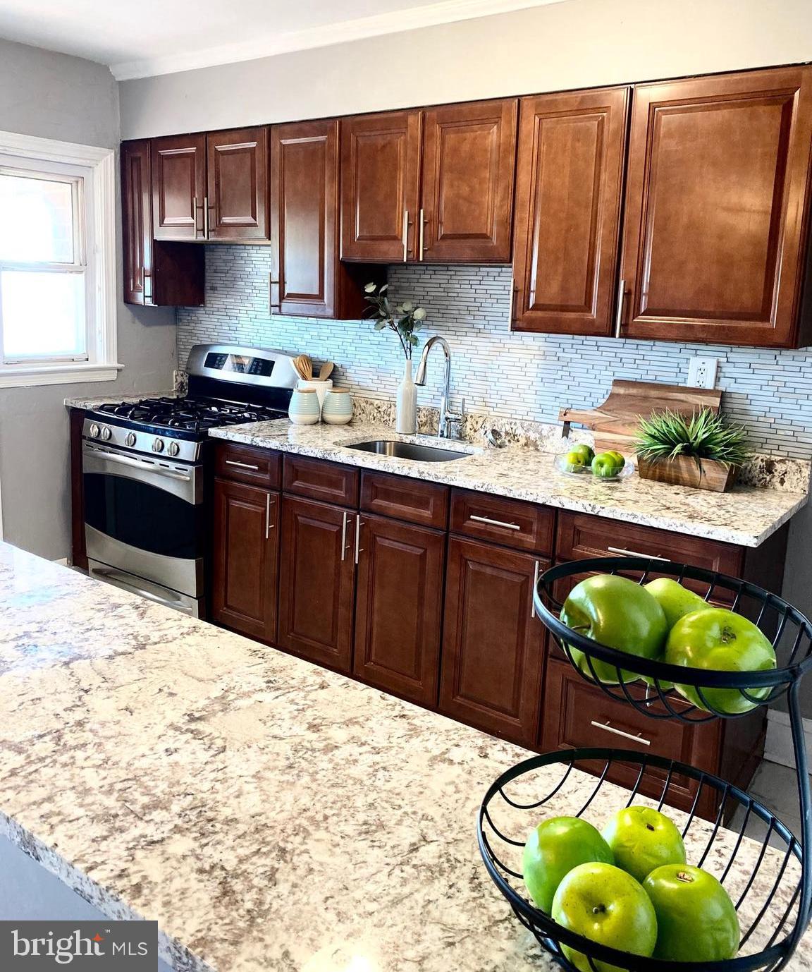 5019 Schaub Avenue Baltimore, MD 21206 - Photo 12 of 34 a kitchen with stainless steel appliances granite countertop a stove a sink and a microwave