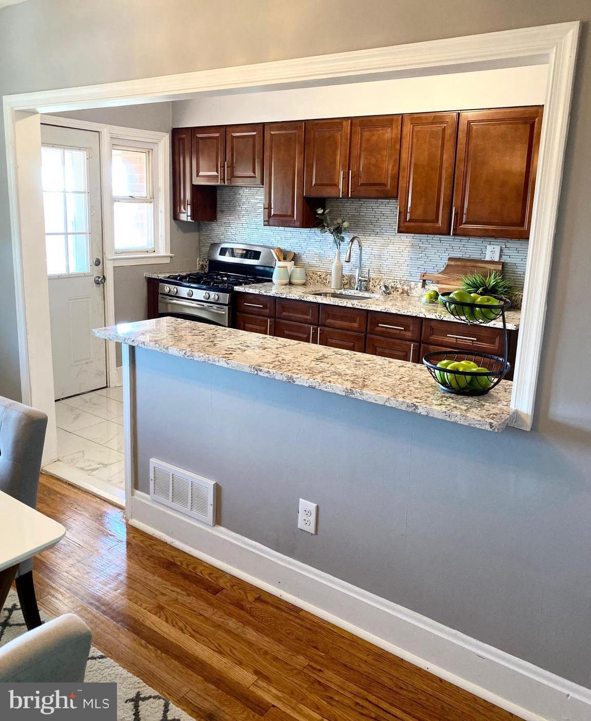 5019 Schaub Avenue Baltimore, MD 21206 - Photo 13 of 34 a kitchen with stainless steel appliances granite countertop a refrigerator a stove and a wooden floors