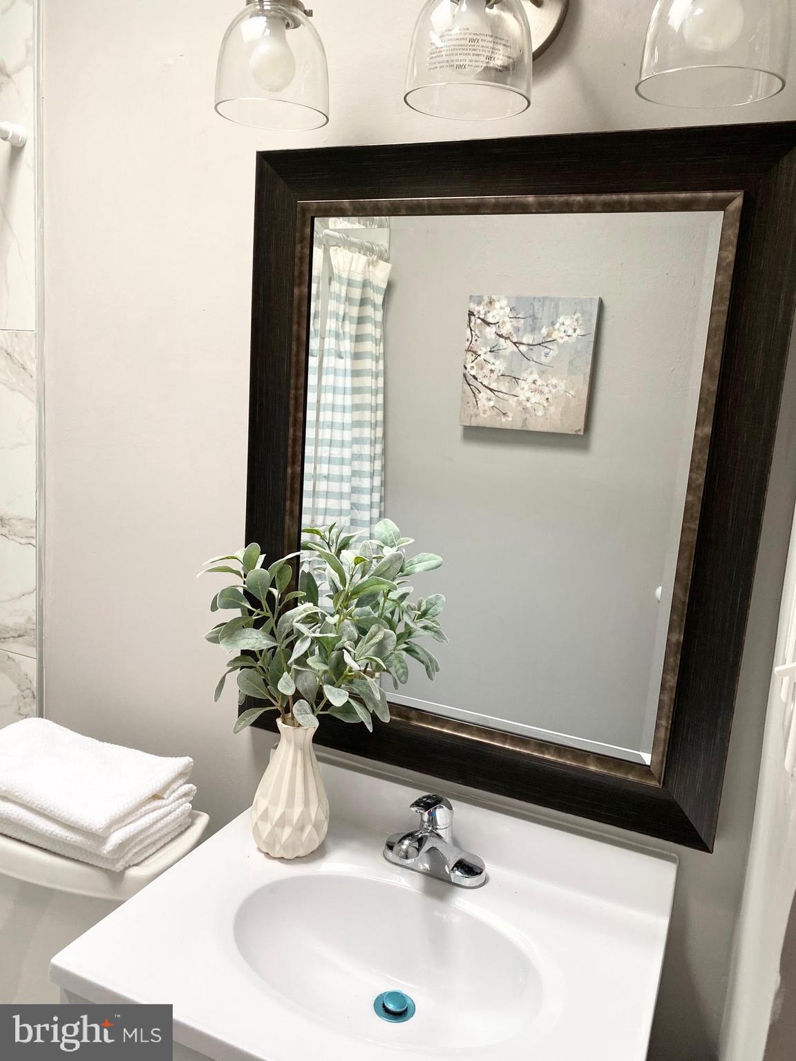 5019 Schaub Avenue Baltimore, MD 21206 - Photo 24 of 34 a bathroom with a sink and a mirror
