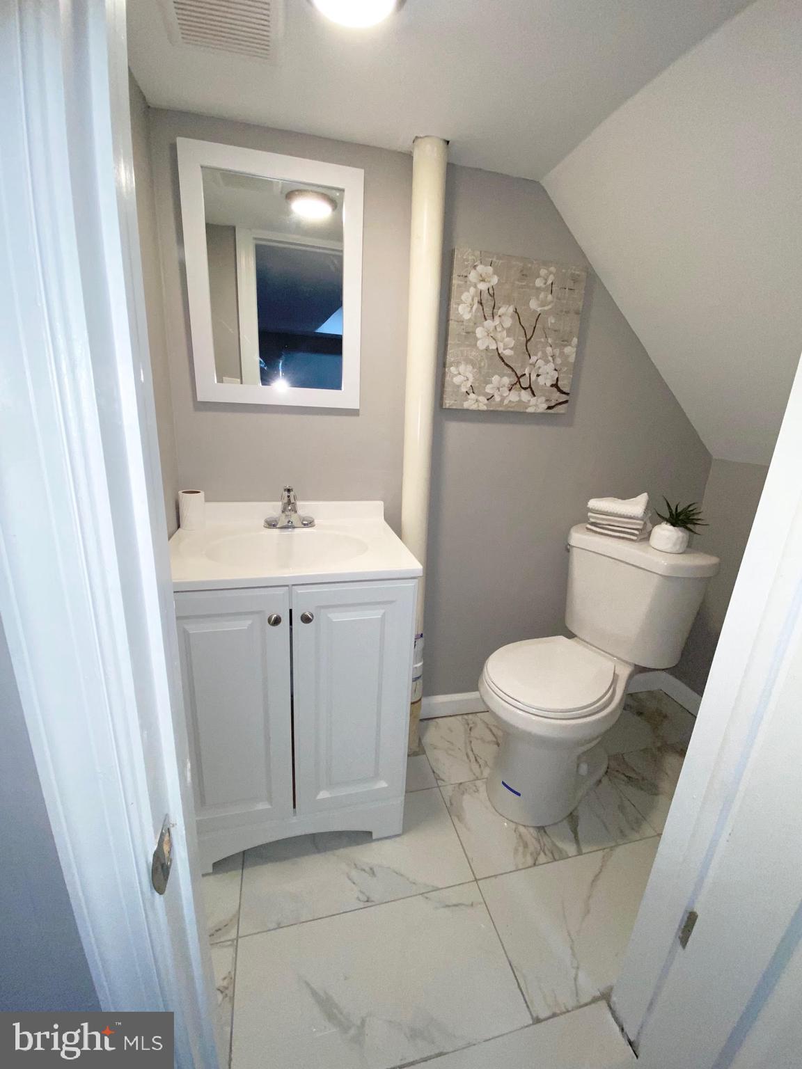 5019 Schaub Avenue Baltimore, MD 21206 - Photo 27 of 34 a bathroom with a toilet sink and mirror