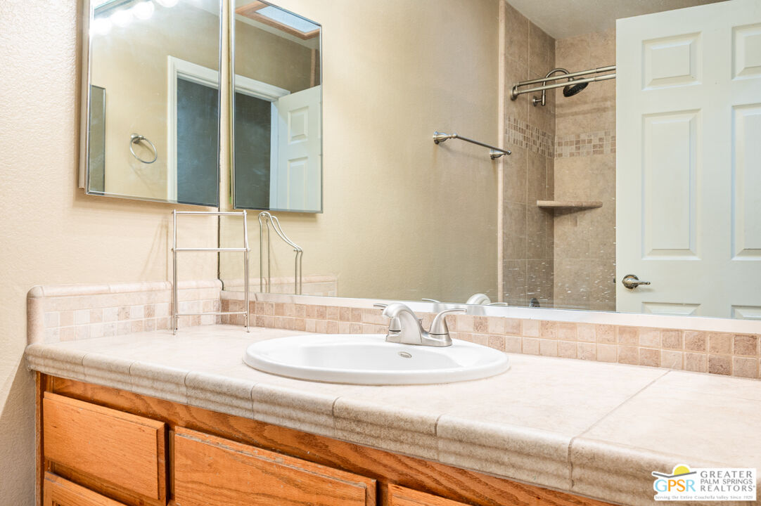 68655 Durango Road Cathedral City, CA 92234 - Photo 23 of 36 a bathroom with a granite countertop sink and a mirror