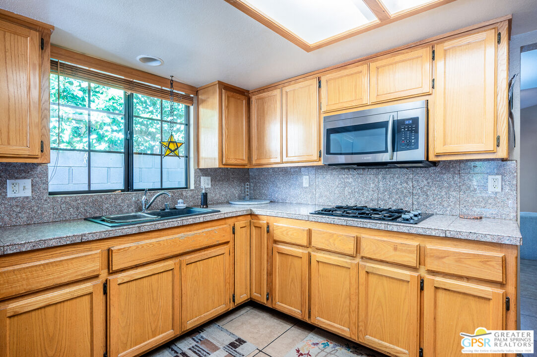 68655 Durango Road Cathedral City, CA 92234 - Photo 7 of 36 a kitchen with stainless steel appliances granite countertop cabinets sink and a large window