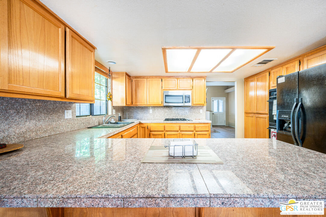 68655 Durango Road Cathedral City, CA 92234 - Photo 8 of 36 a large kitchen with stainless steel appliances granite countertop a sink and cabinets