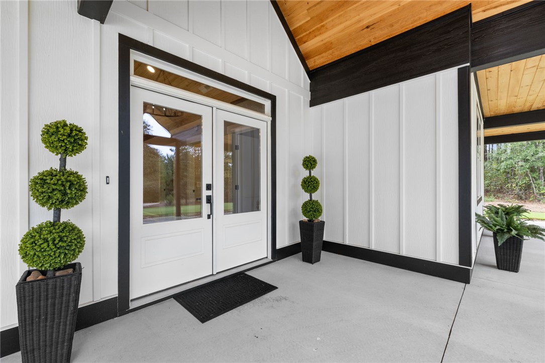 147 McAlister Road West Union, SC 29696 - Photo 4 of 50 Striking glass-inset double doors welcome visitors beneath a handsome wood-lined covered entryway.