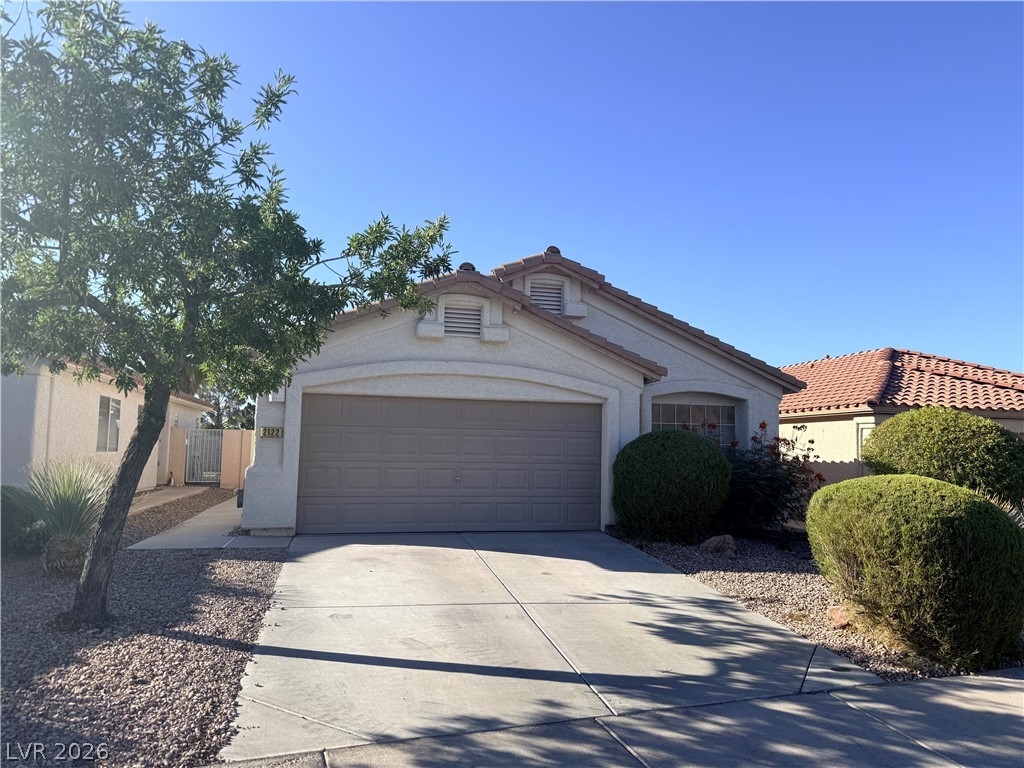 A welcoming driveway leads to a charming residence, framed by mature trees and well-maintained shrubbery.