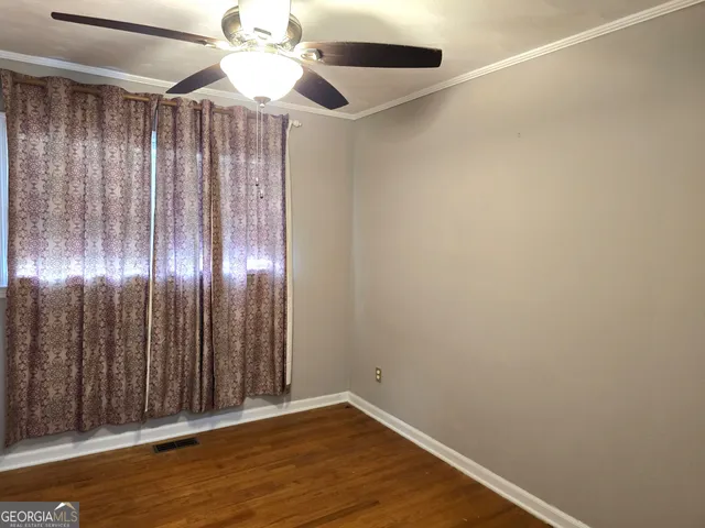 a view of an empty room with wooden floor