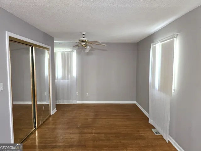 a view of an empty room with wooden floor