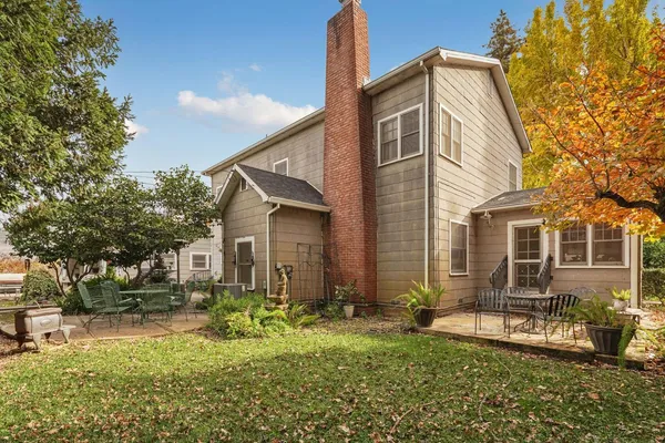 a view of a house with backyard and sitting area