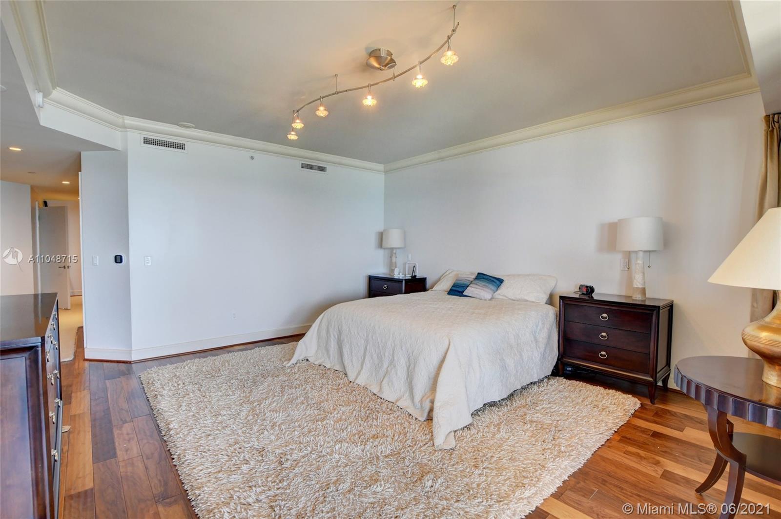 2500 South Ocean Boulevard, Unit 702 Boca Raton, FL 33432 - Photo 37 of 61 a bedroom with a bed and wooden floor