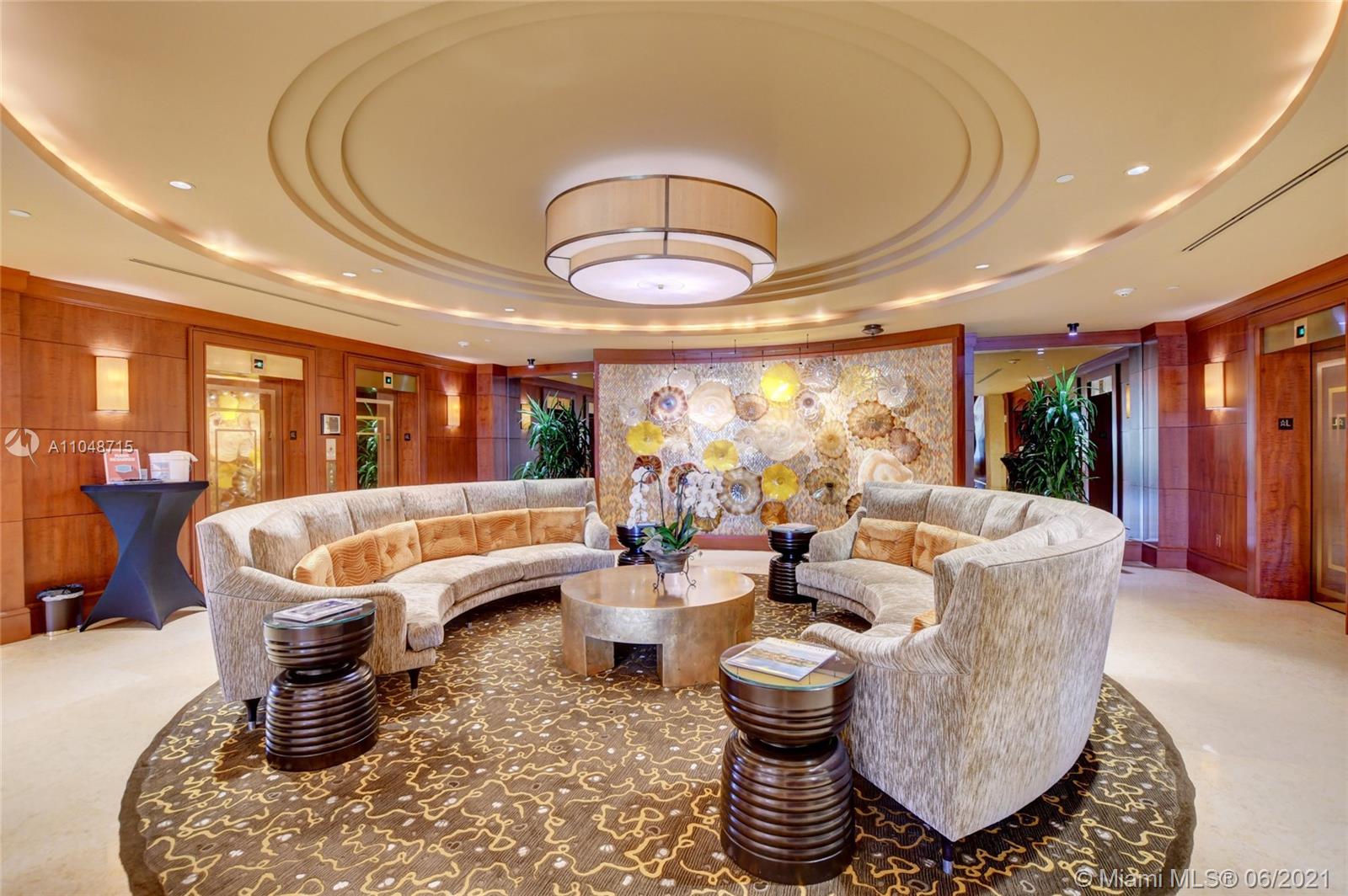 2500 South Ocean Boulevard, Unit 702 Boca Raton, FL 33432 - Photo 46 of 61 a living room with furniture a chandelier and a large window