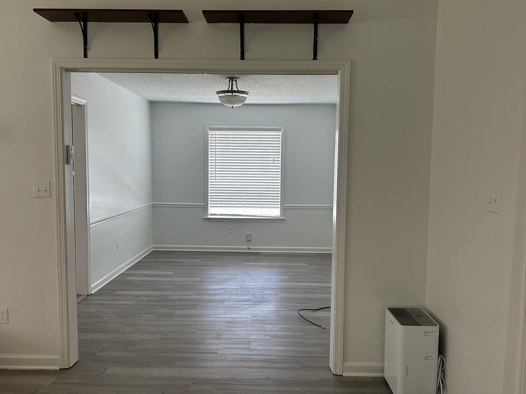 1441 Milestone Drive Collierville, TN 38017 - Photo 3 of 16 a view of an empty room with wooden floor and a window