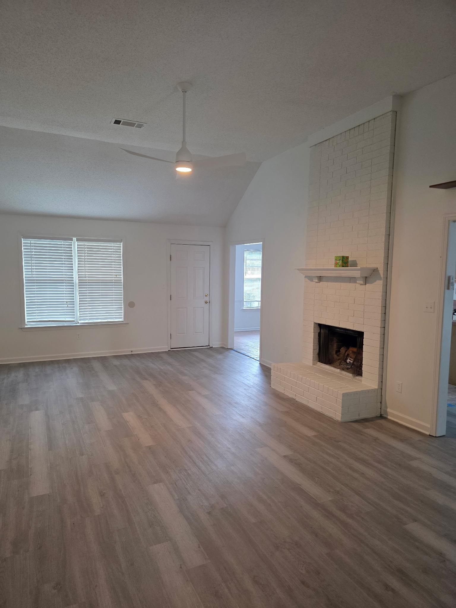 1441 Milestone Drive Collierville, TN 38017 - Photo 4 of 16 an empty room with wooden floor and fireplace