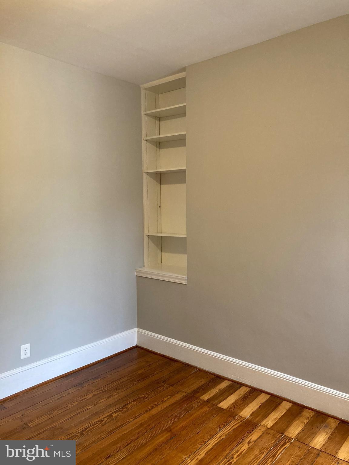 1338 Wisconsin Avenue Northwest, Unit 2 Washington, DC 20007 - Photo 4 of 11 a view of an empty room with wooden floor and a window