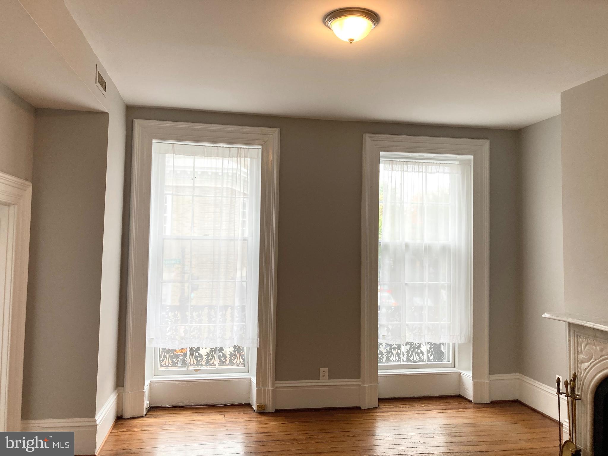 1338 Wisconsin Avenue Northwest, Unit 2 Washington, DC 20007 - Photo 6 of 11 a view of an empty room with wooden floor and a window