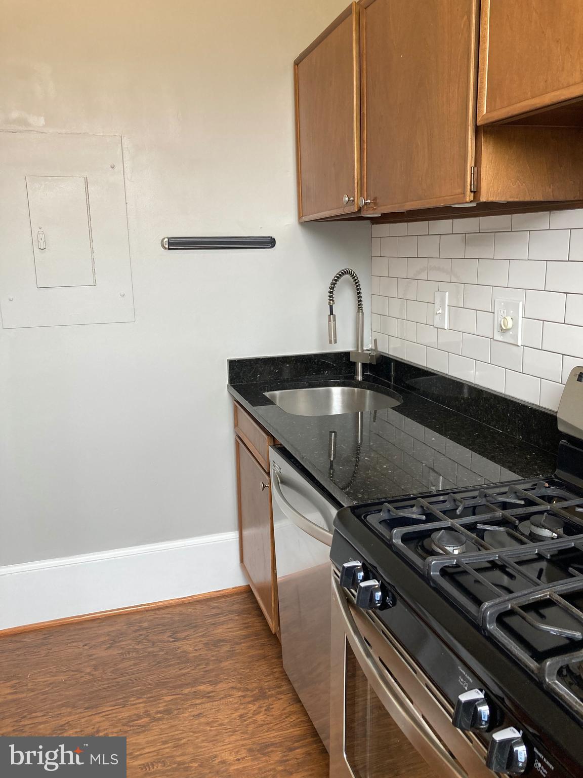 1338 Wisconsin Avenue Northwest, Unit 2 Washington, DC 20007 - Photo 7 of 11 a kitchen with granite countertop a sink stove and cabinets
