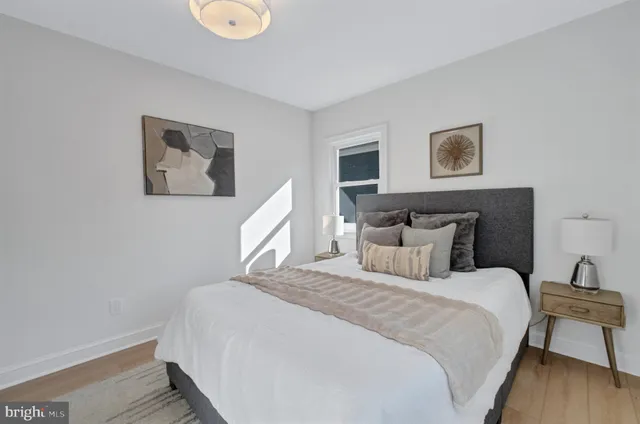 a bedroom with bed and a painting on the wall