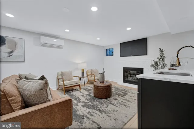 a living room with furniture a flat screen tv and a fireplace