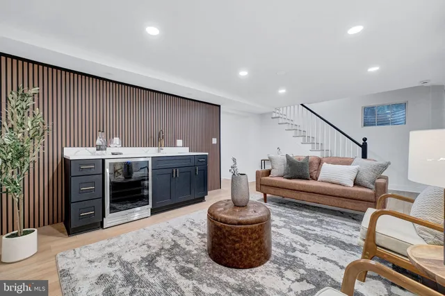 a living room with furniture a rug and kitchen view