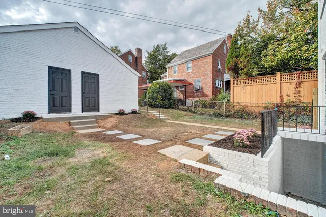 a view of a house with backyard and trees