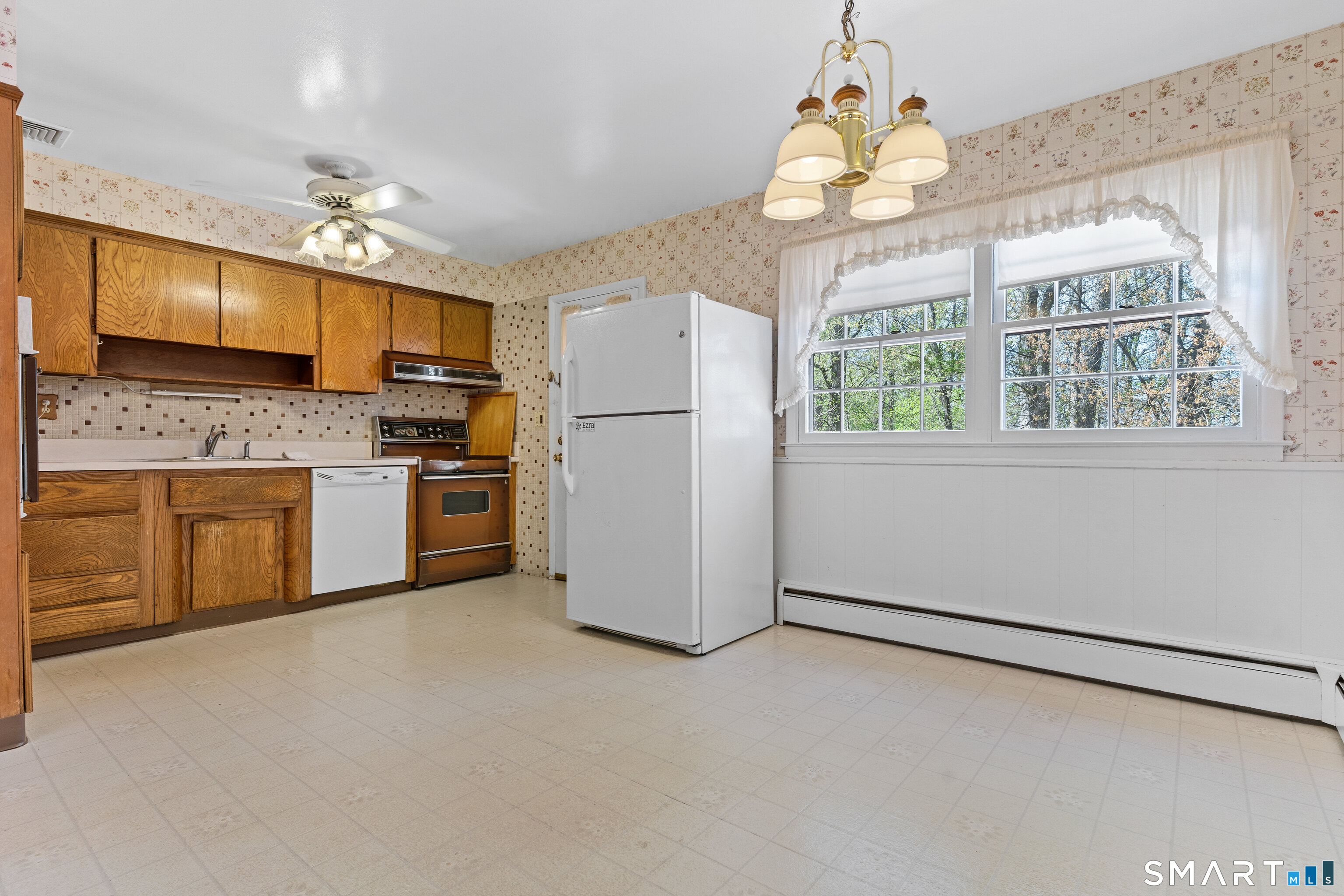 251 Shelter Rock Road Fairfield, CT 06825 - Photo 13 of 38 a kitchen with kitchen island a stove a sink cabinetry and a chandelier