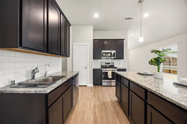 a kitchen with granite countertop stainless steel appliances and sink