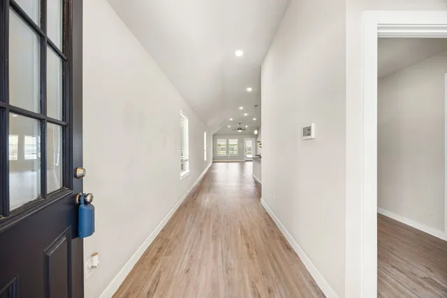 a view of a hallway with wooden floor and staircase