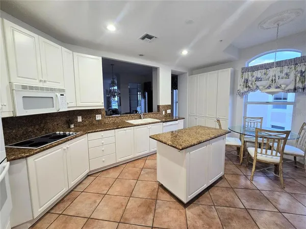 a kitchen with granite countertop a sink a stove and cabinets