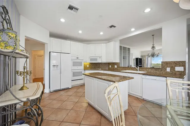 a kitchen with stainless steel appliances granite countertop a sink and a refrigerator