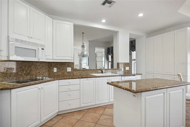 a kitchen with granite countertop white cabinets and a sink