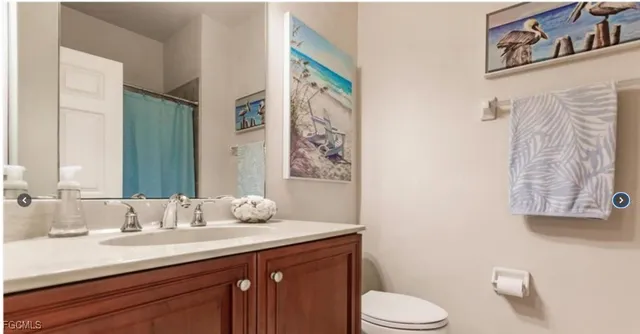 a bathroom with a granite countertop sink toilet and mirror