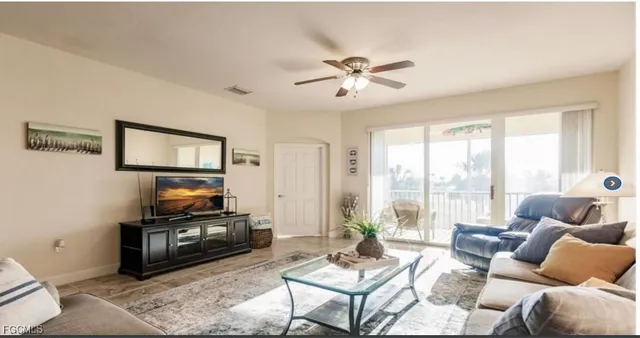 a living room with furniture a flat screen tv and a large window