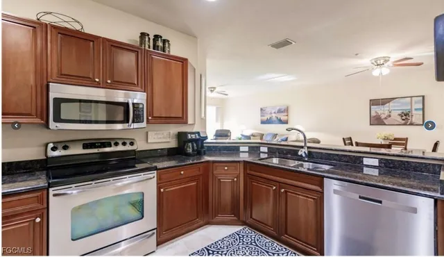 a kitchen with stainless steel appliances granite countertop a sink stove and microwave