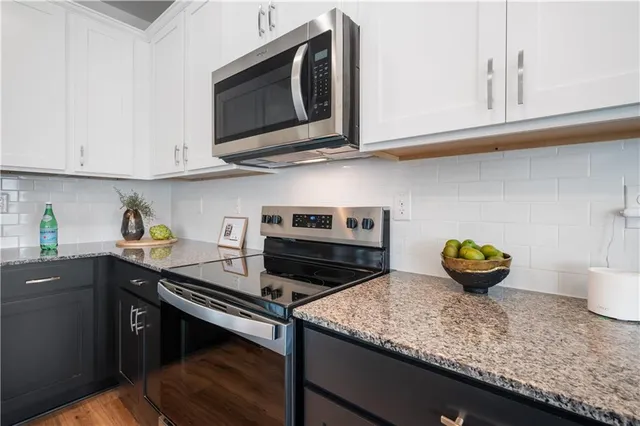 a kitchen with stainless steel appliances granite countertop a sink a stove and cabinets