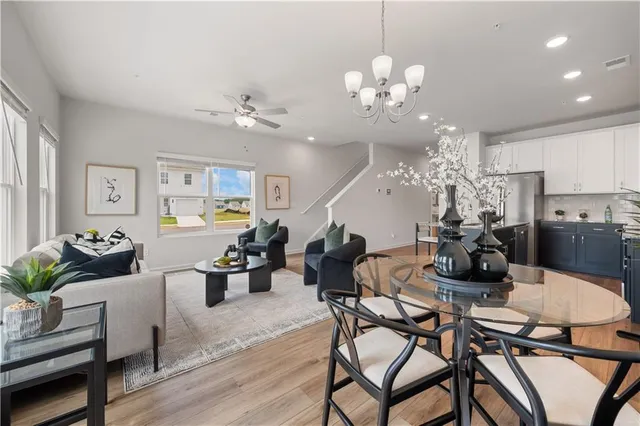 a view of a dining room with furniture a chandelier and wooden floor