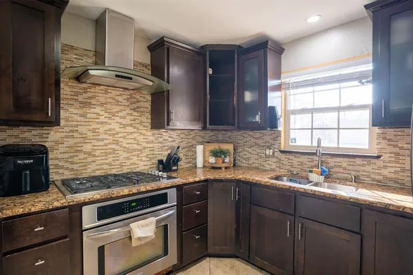a kitchen with stainless steel appliances granite countertop a sink stove and cabinets