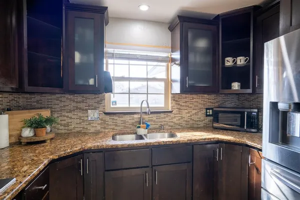 a kitchen with stainless steel appliances granite countertop a sink stove and cabinets