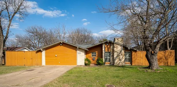 a view of a house with a big yard and large trees