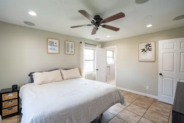 a bedroom with a large bed and a ceiling fan