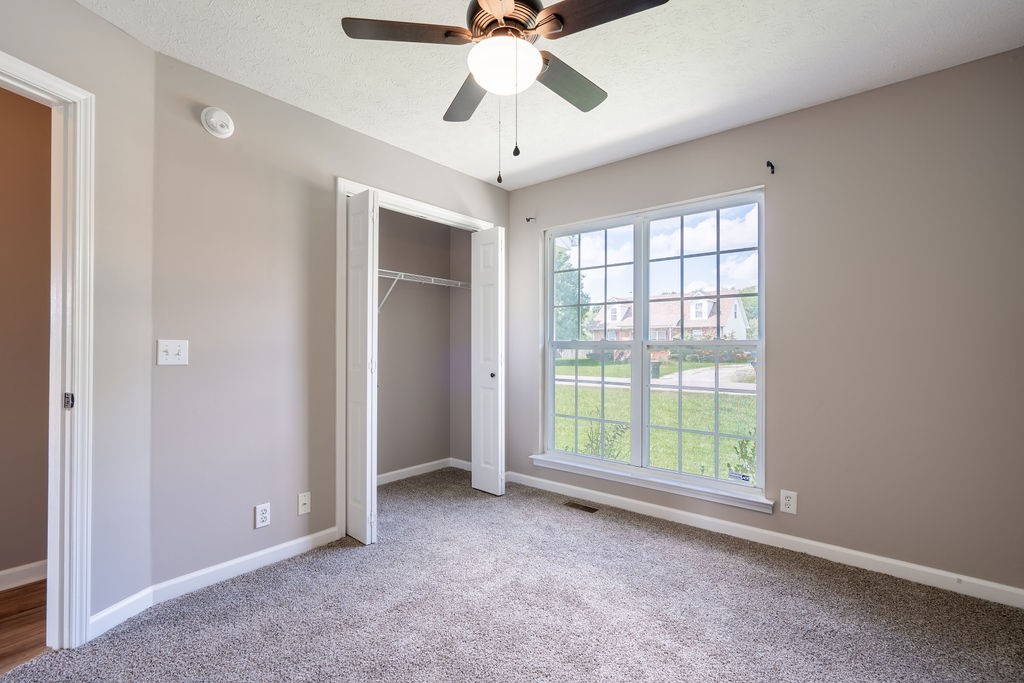 122 Cora Street Portland, TN 37148 - Photo 24 of 28 an empty room with a chandelier fan and windows