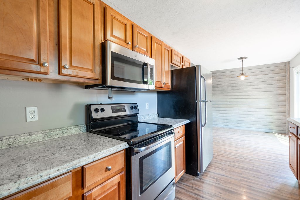 122 Cora Street Portland, TN 37148 - Photo 25 of 28 a kitchen with stainless steel appliances granite countertop a stove microwave and cabinets