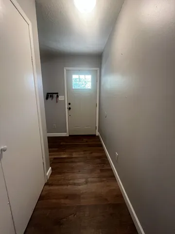 a view of a hallway with wooden floor and staircase