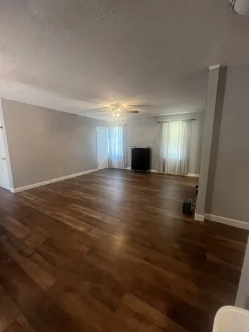 a view of an empty room with wooden floor